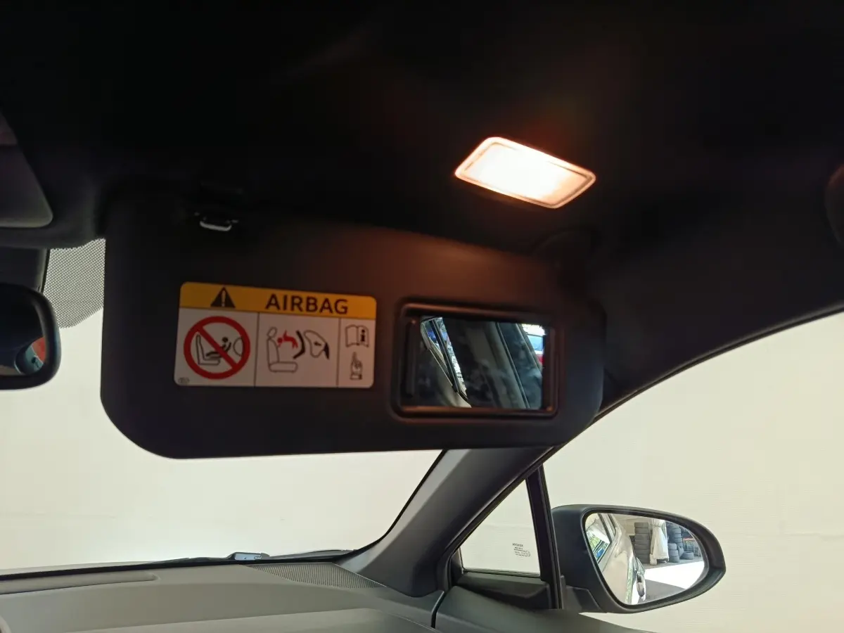 Vue intérieure du pare-soleil côté conducteur avec miroir et lumière allumée dans un Toyota C-HR gris clair.