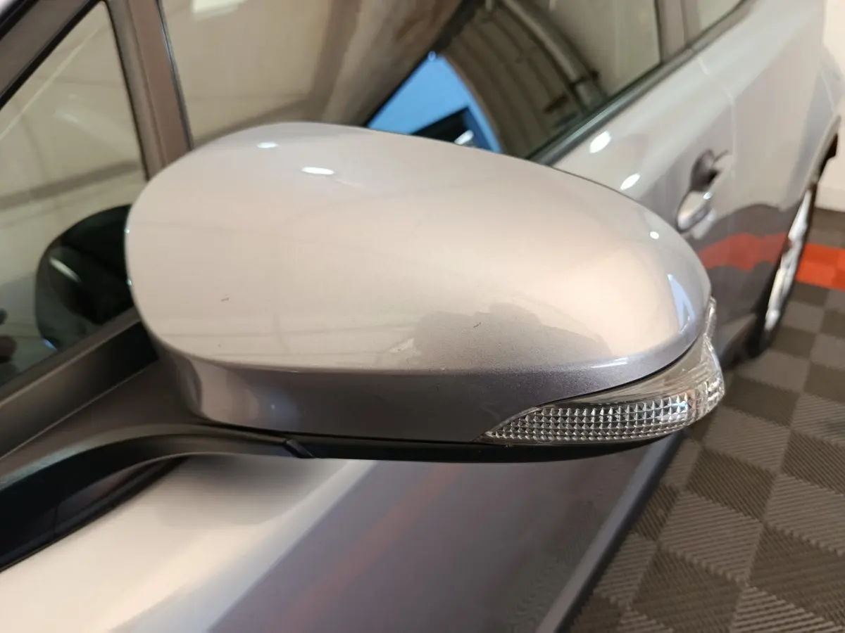 Rétroviseur côté gauche gris clair du Toyota C-HR 2.0 Hybride 184, avec clignotant intégré, vue rapprochée.