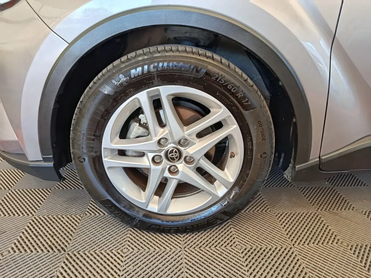 Gros plan sur la roue avant droite gris clair du Toyota C-HR 2.0 Hybride 184 avec jante alliage et pneu Michelin.