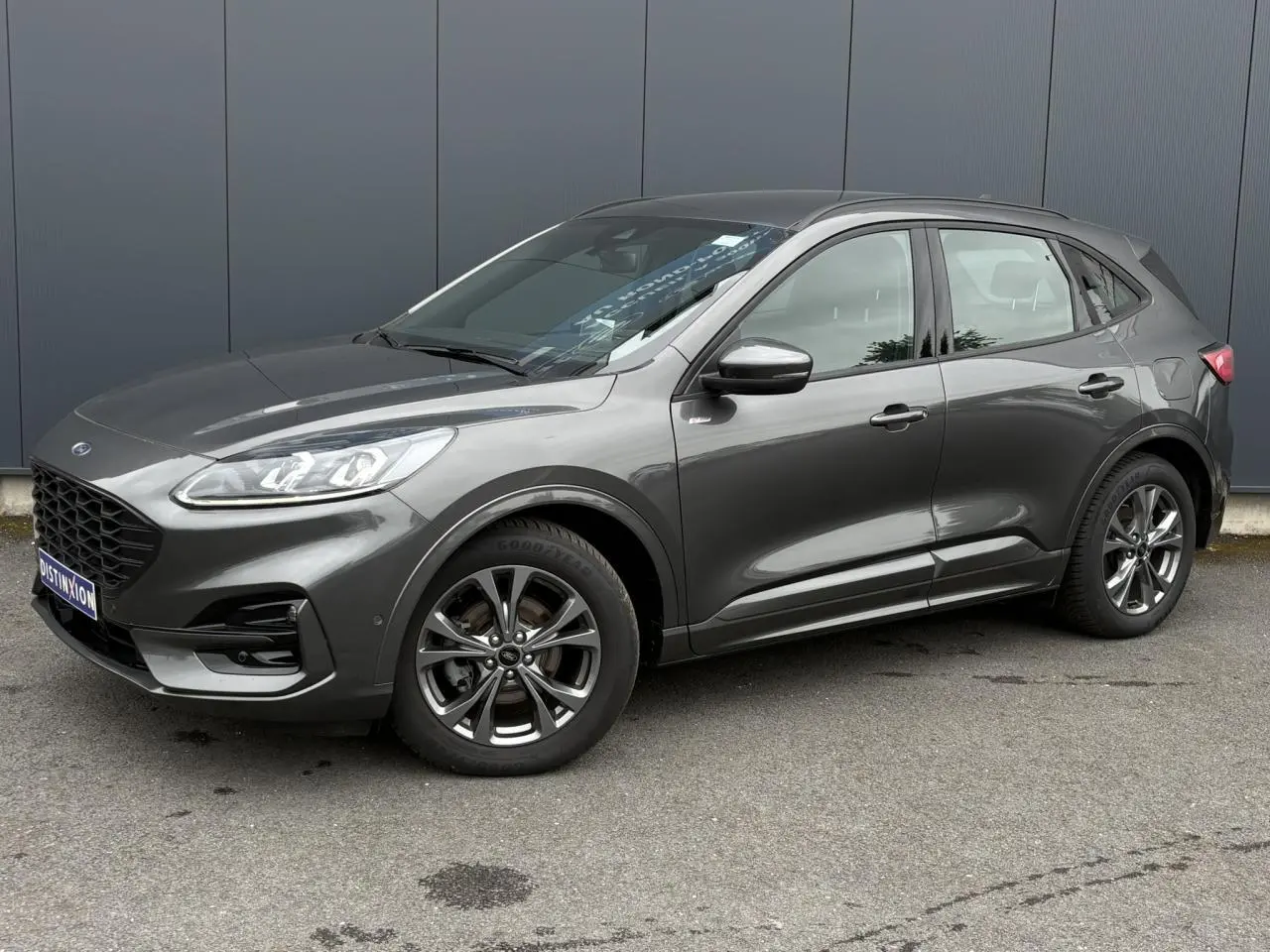 Ford Kuga 2.0 EcoBlue gris graphite, vue côté droit en 3/4 avant, jantes alliage et phares LED visibles.