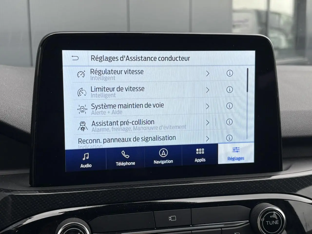 Écran tactile central du Ford Kuga 2023 affichant les réglages d’assistance conducteur en intérieur noir.