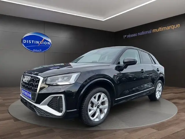 Audi Q2 noir mito en 3/4 avant droit, avec jantes alliage 17 pouces et calandre S-Line distinctive.