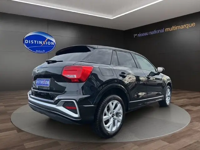 Audi Q2 noir mito vue 3/4 arrière droit, jantes alliage 17 pouces et hayon motorisé en showroom.