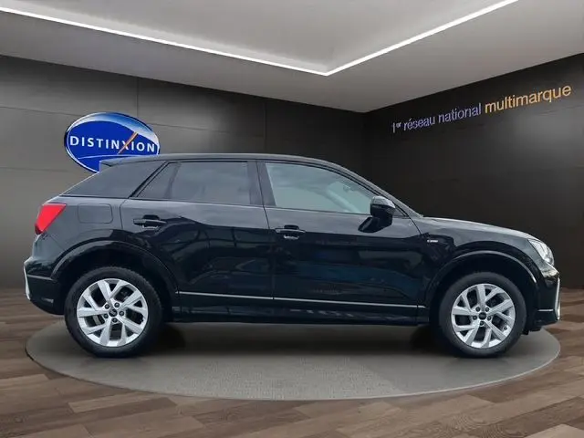 Audi Q2 noir mito vue de profil côté gauche, mettant en valeur ses jantes alliage 17 pouces et sa silhouette compacte.