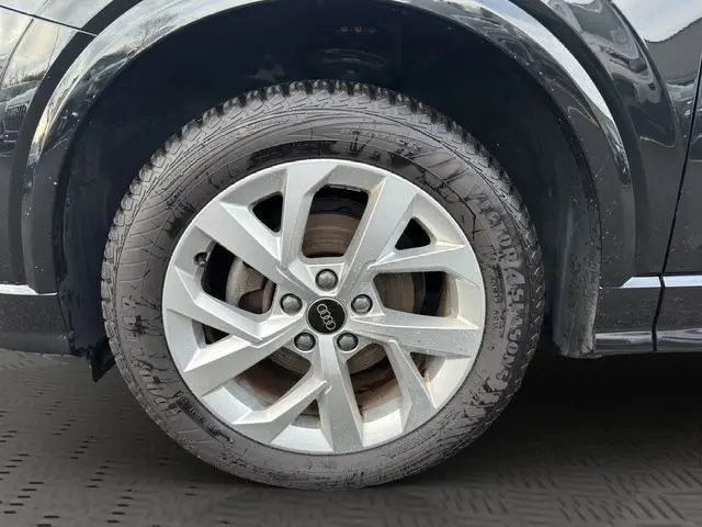 Gros plan sur la roue avant droite d’un Audi Q2 noir Mito, jante alliage 7x17 à 5 branches en Y.
