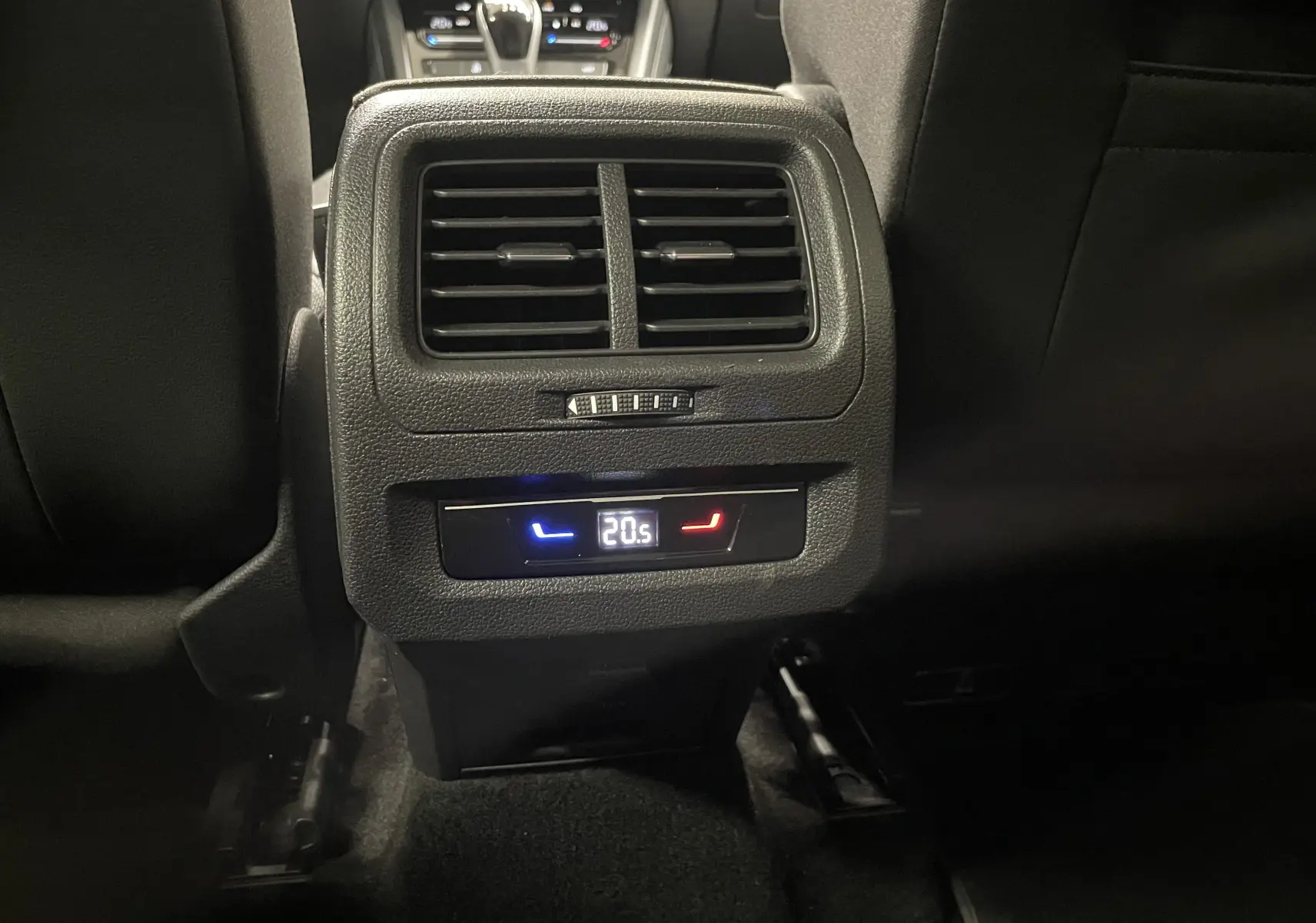 Vue rapprochée des commandes de climatisation arrière dans l'habitacle noir du Volkswagen Touran Gris Dauphin 2024.