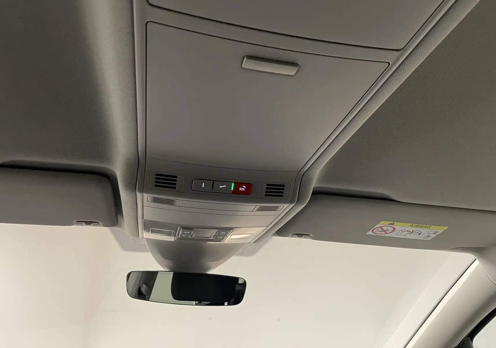 Plafonnier intérieur avec commandes SOS et éclairage, rétroviseur et pare-soleil du Volkswagen Touran gris dauphin 2024.