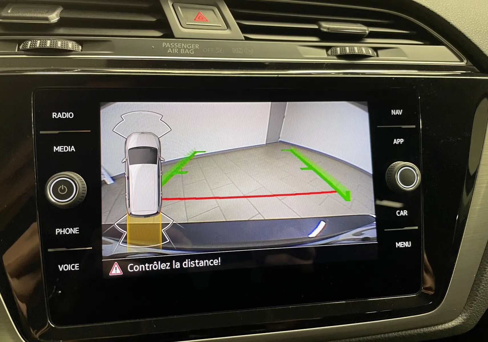 Affichage de la caméra de recul du Volkswagen Touran gris Dauphin 2024 avec guidage de trajectoire sur l'écran central.