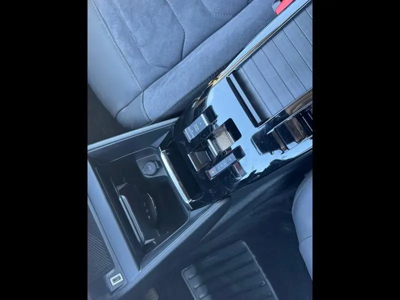 Gros plan sur la console centrale noire brillante du Citroën C4 gris 2024, montrant la boîte manuelle et le siège côté droit.