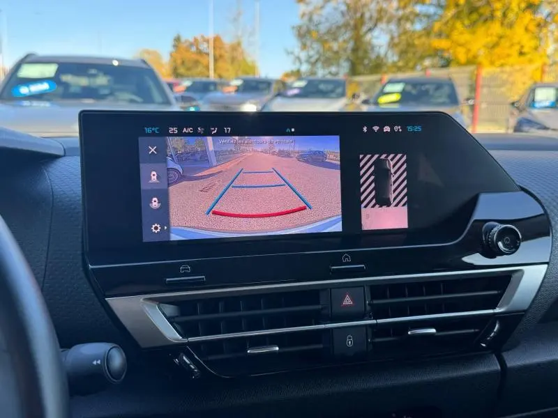 Vue intérieure du tableau de bord du Citroën C4 2024 gris, écran multimédia affichant la caméra de recul avec guidage coloré.