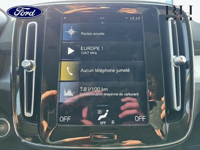 Écran tactile central du tableau de bord du Volvo XC40 T5 Recharge gris Glacier, avec affichage radio et consommation.