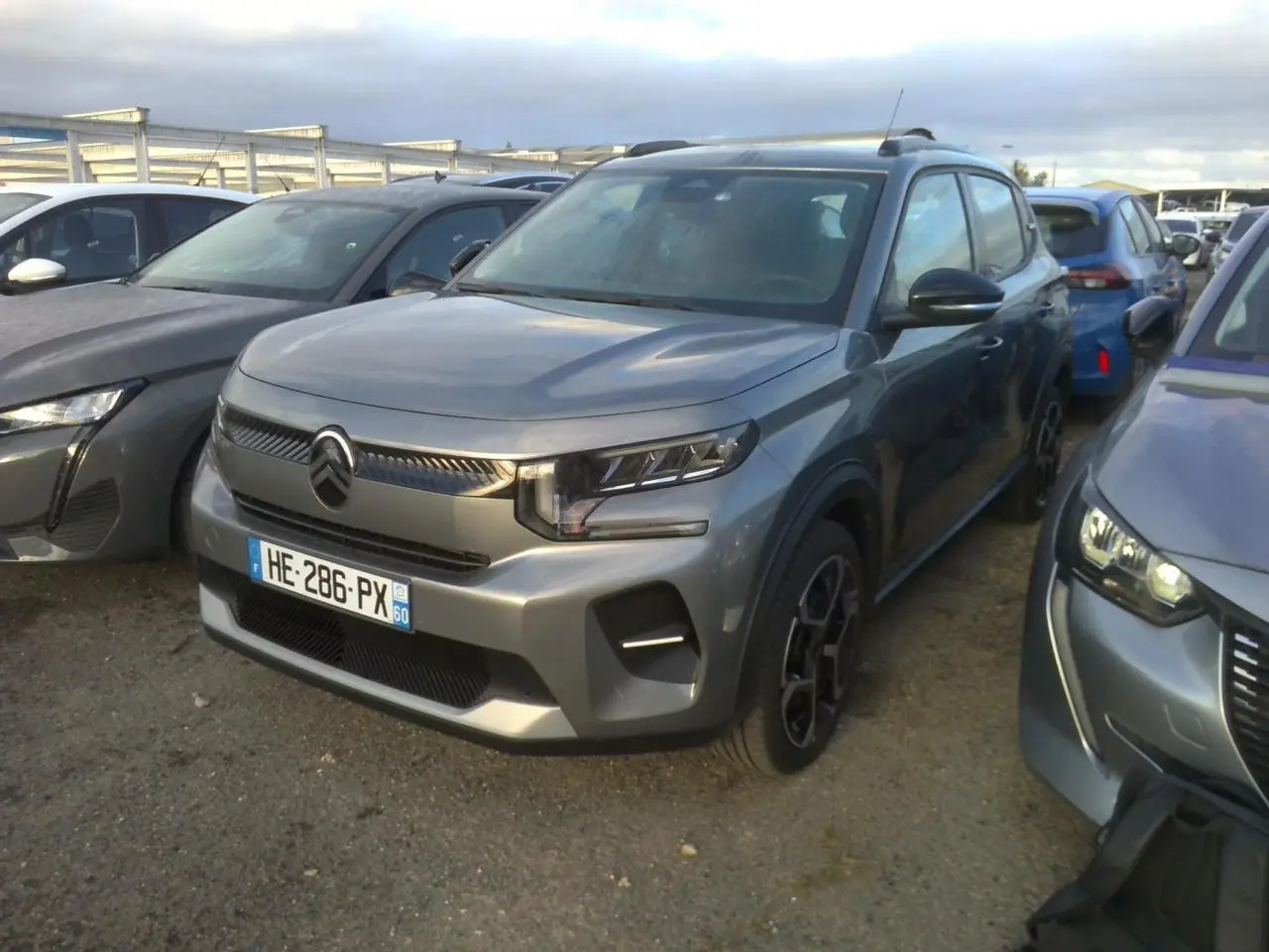 Vue 3/4 avant d'une Citroën C3 2025 gris foncé avec barres de toit noir brillant et jantes 17 pouces Azurite.