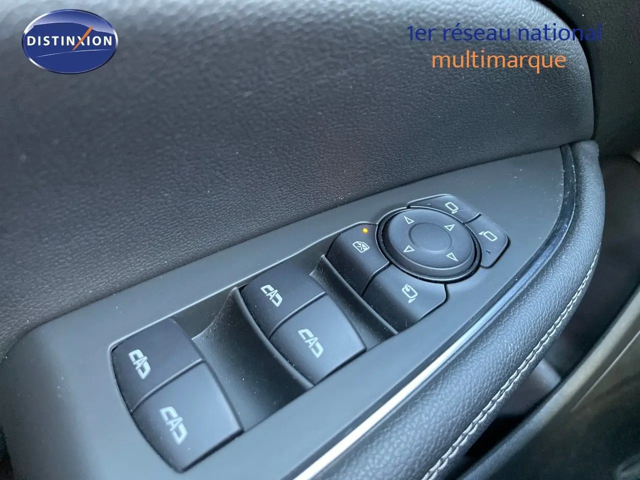 Gros plan sur les commandes des vitres et rétroviseurs côté conducteur d'une Opel Insignia gris minéral métal.