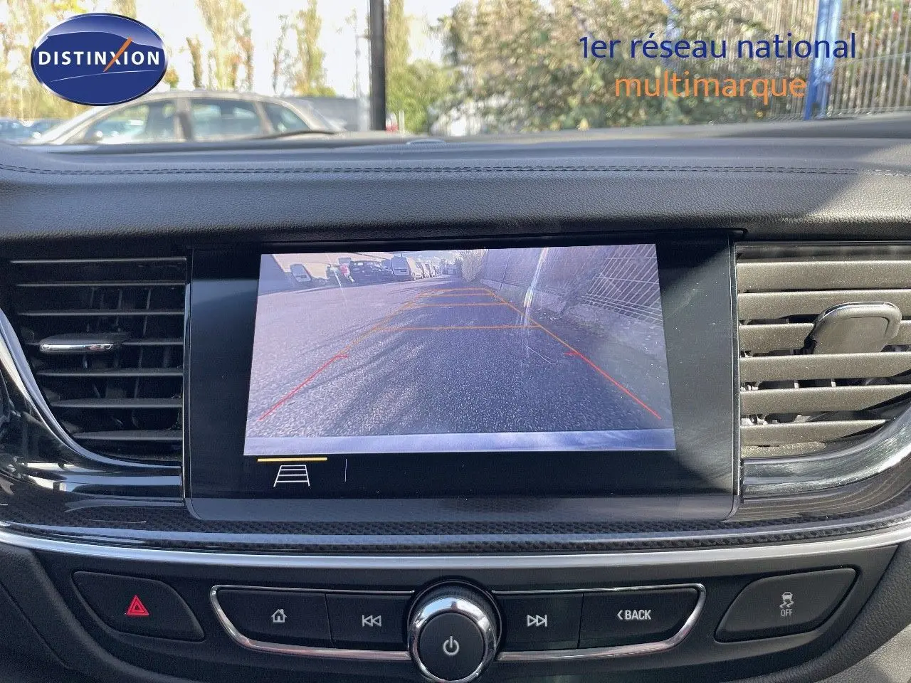 Écran de caméra de recul affichant la vue arrière d'une Opel Insignia gris minéral métal, tableau de bord moderne noir.