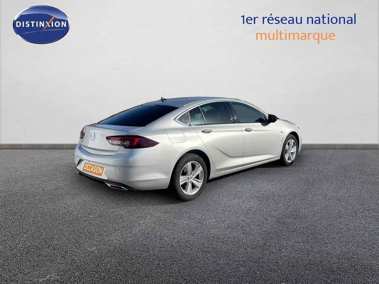 Opel Insignia gris minéral métal vue 3/4 arrière droit sur fond neutre avec vitres teintées et jantes alliage.