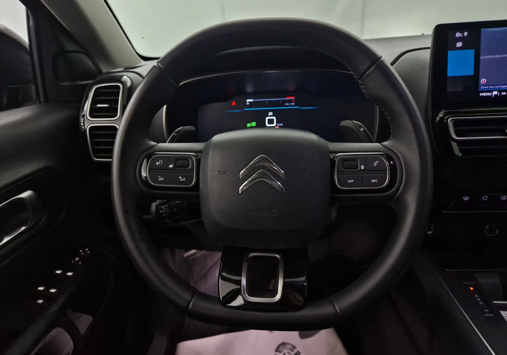 Vue frontale du volant cuir noir du Citroën C5 Aircross 2024 avec commandes intégrées et tableau de bord numérique.