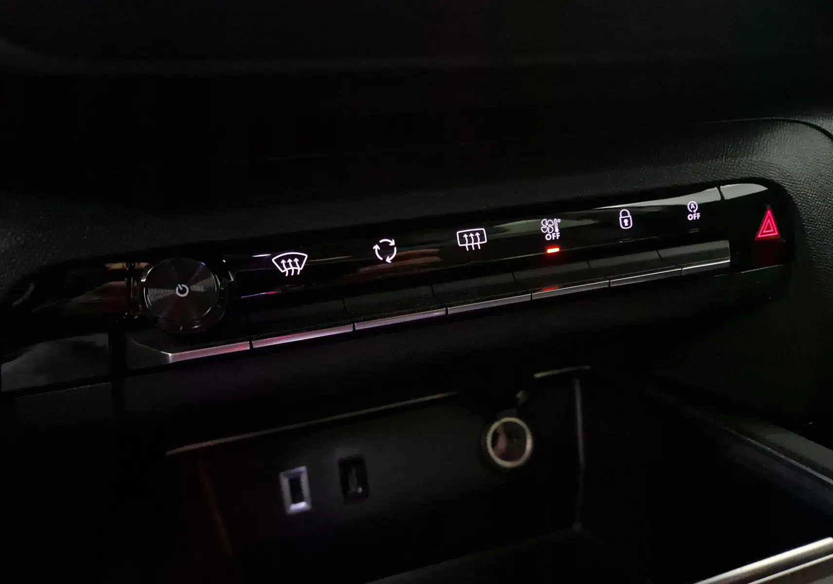 Panneau de commandes climatisation et sécurité intérieur noir du Citroën C5 Aircross 2024 avec boutons lumineux blancs et rouge.