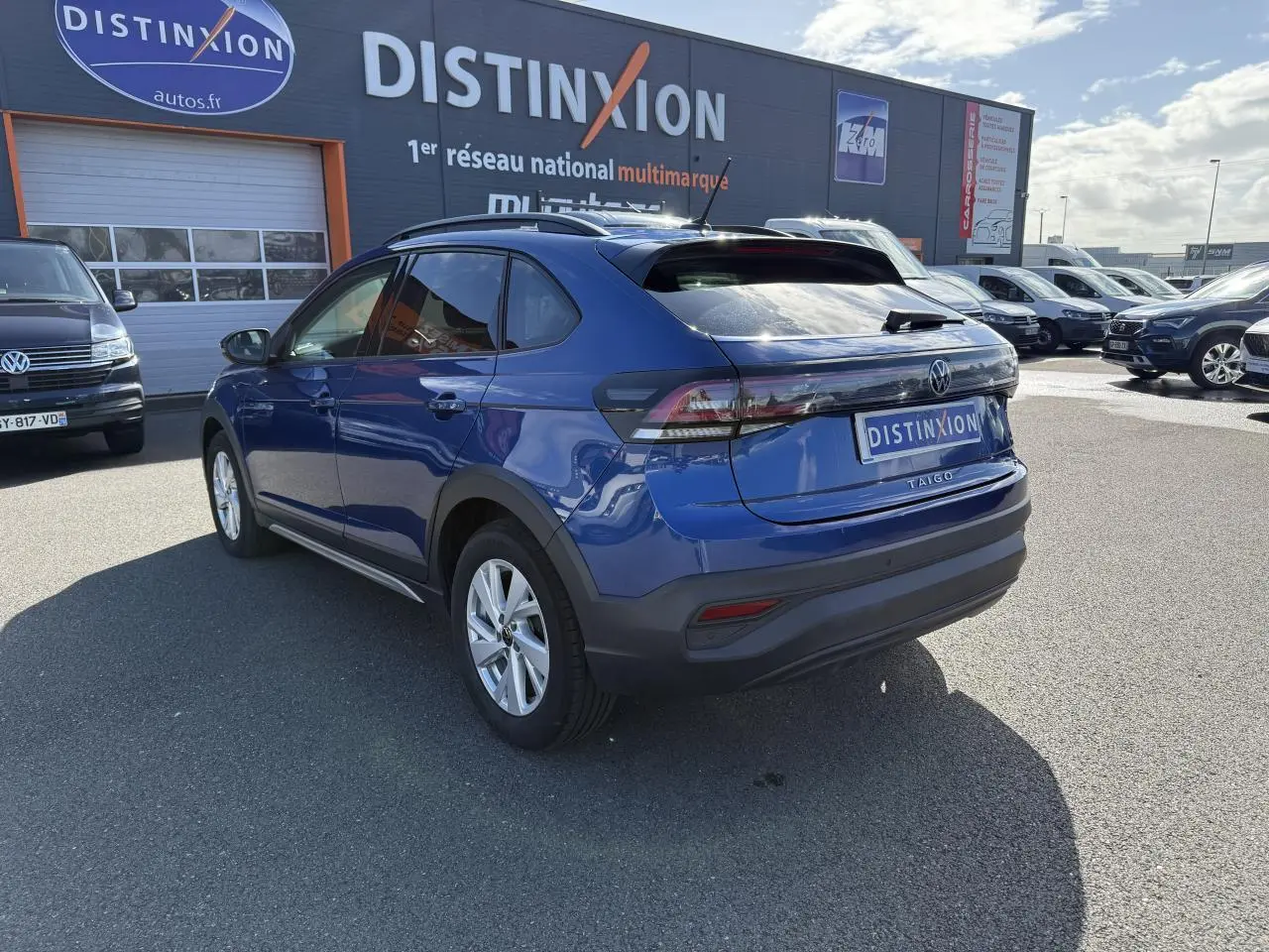 Volkswagen Taigo bleu récif métallisé vu en 3/4 arrière droit, avec feux arrière LED et toit noir contrasté.
