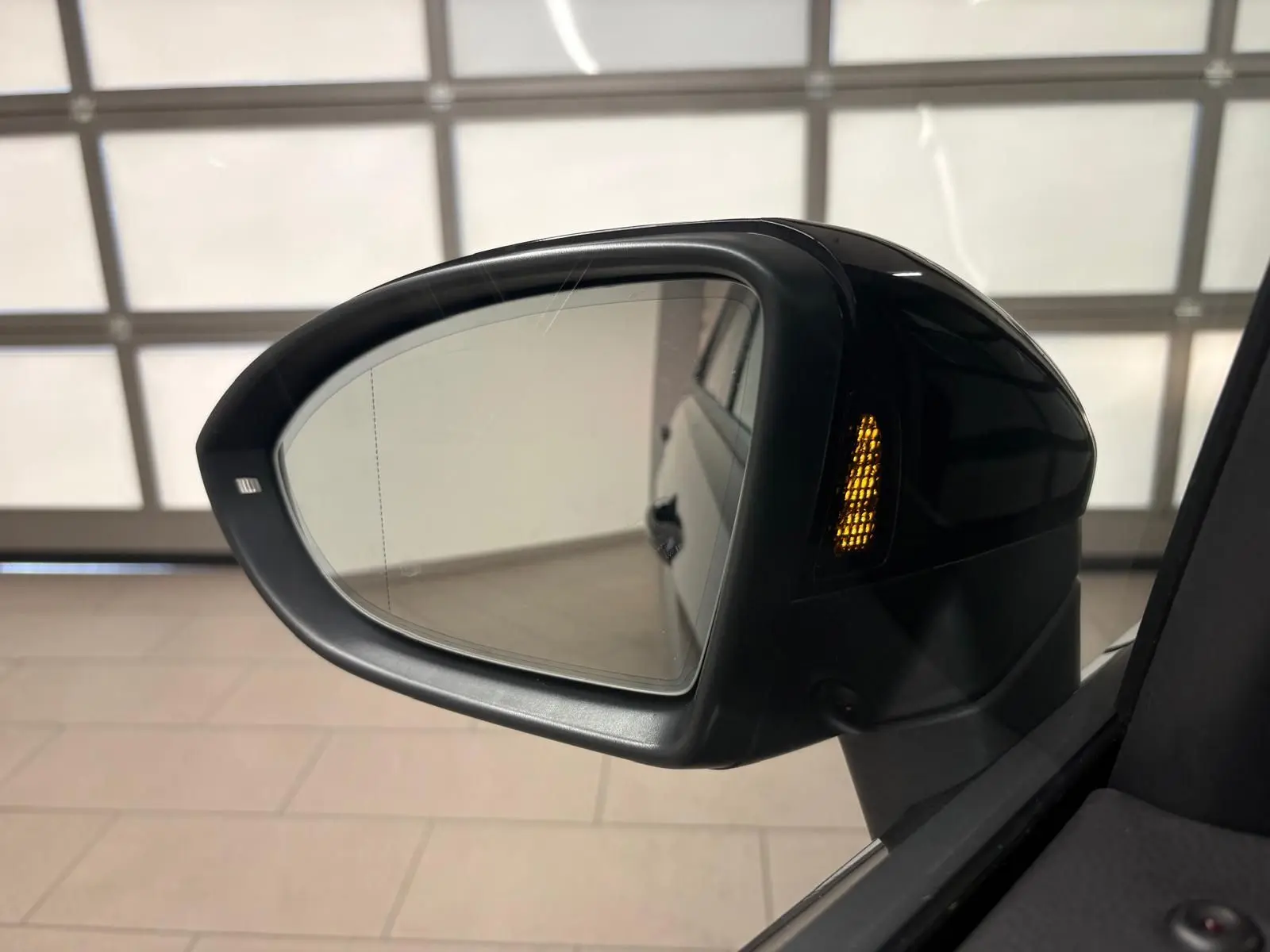 Rétroviseur extérieur droit noir intense nacré du Volkswagen Touran 2024 avec clignotant intégré allumé.