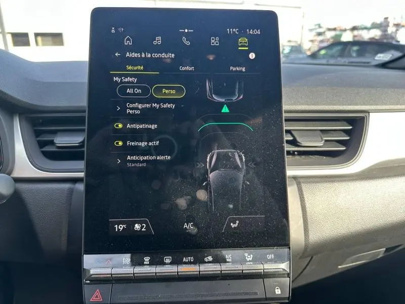 Écran tactile central du tableau de bord du Renault Captur 2025 montrant les aides à la conduite et la climatisation.
