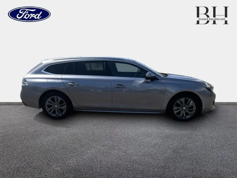 Profil droit d'une Peugeot 508 SW gris Artense, break élégant avec vitres surteintées et jantes alliage.