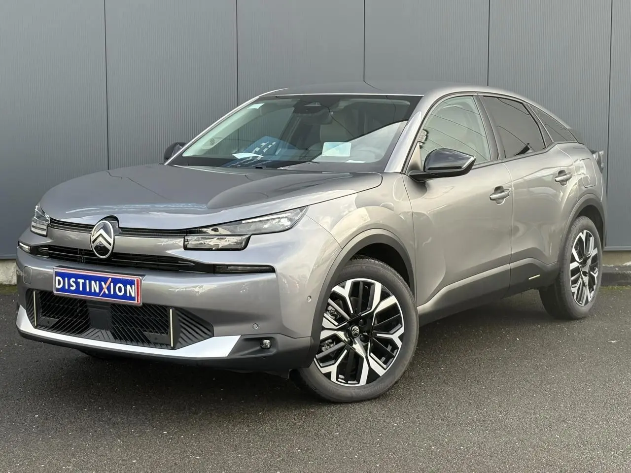 Vue 3/4 avant d'une Citroën C4 Hybrid 145 gris Mercury avec jantes alliage 18 pouces et calandre noire brillante.