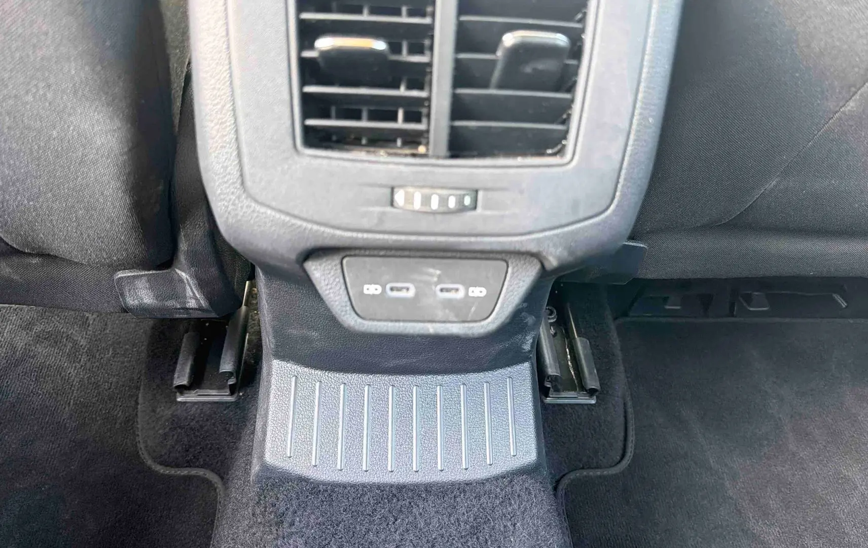 Vue intérieure centrée sur la console arrière noire du Volkswagen T-Roc 2025 avec prises USB et aérateurs.