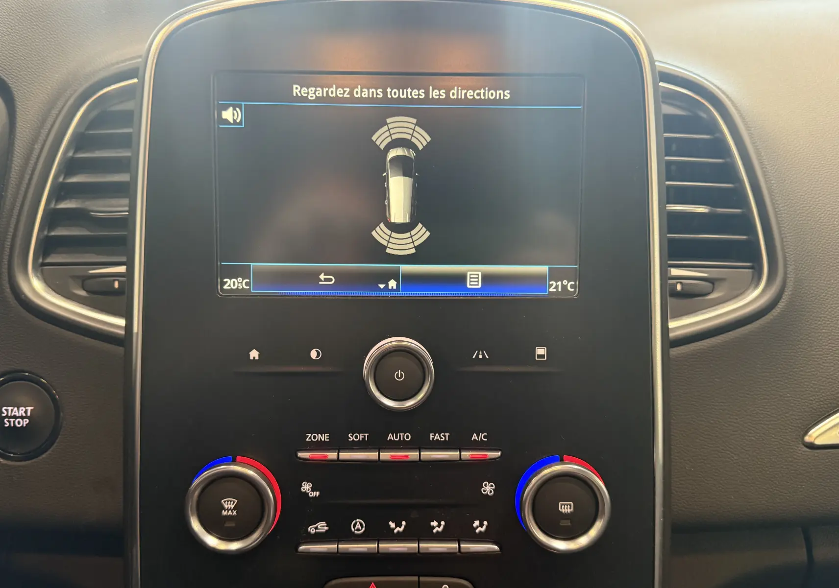 Vue rapprochée du tableau de bord du Renault Grand Scenic IV Business 2020, écran central avec aide au stationnement et commandes climatisation.