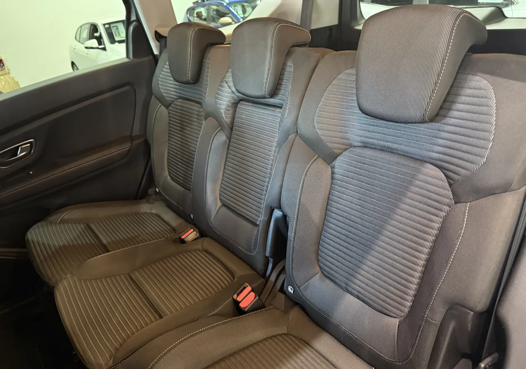 Vue latérale des sièges arrière en tissu gris foncé du Renault Grand Scenic IV Business, soulignant leur confort et design moderne.