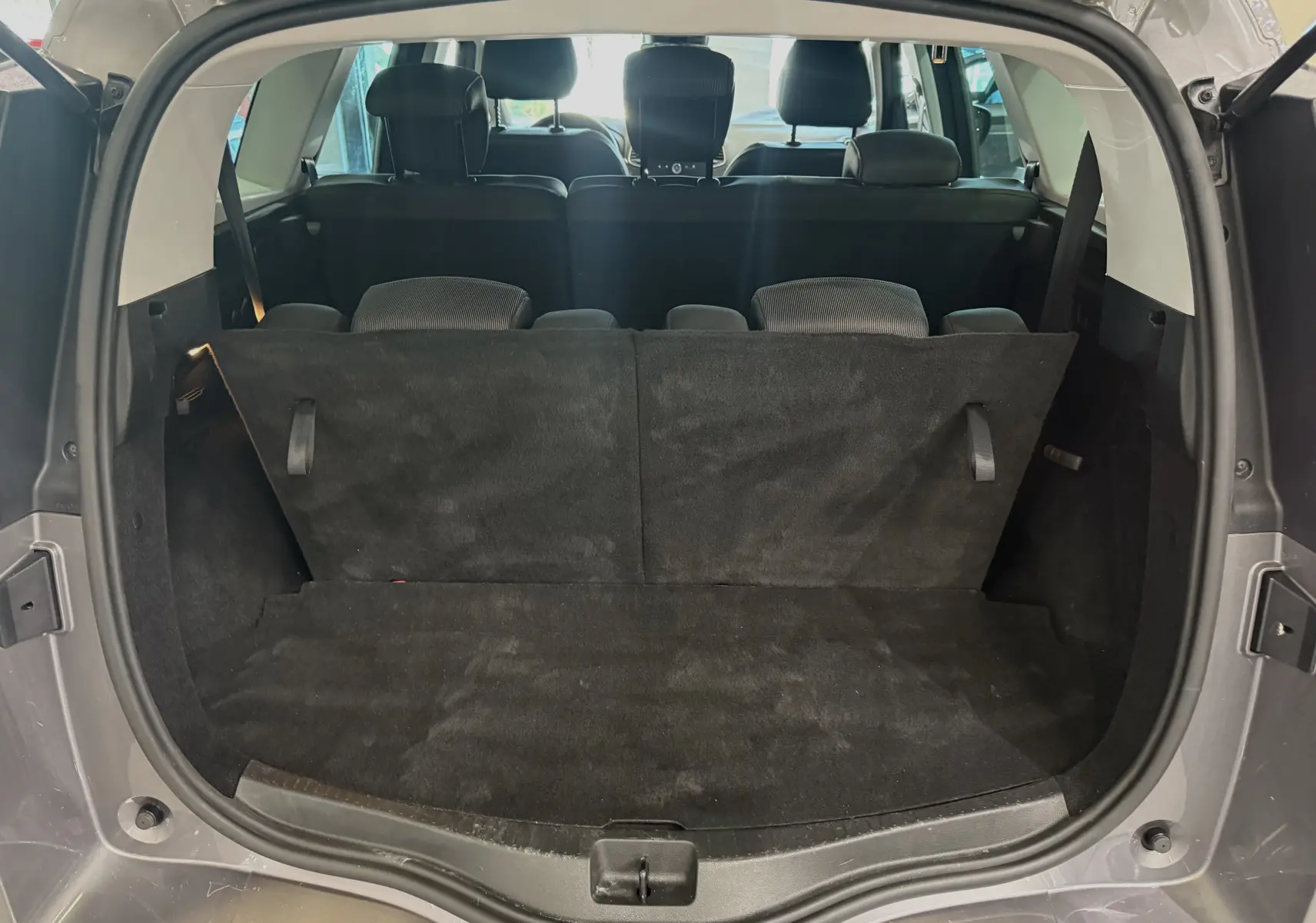 Coffre ouvert vu de l'arrière du Renault Grand Scenic IV Business gris Cassiopée avec banquette arrière relevée.
