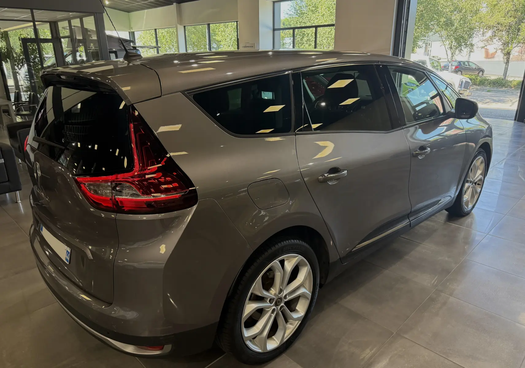 Renault Grand Scenic IV Business gris cassiopée vu en 3/4 arrière droit, avec feux arrière LED et jantes alliage.