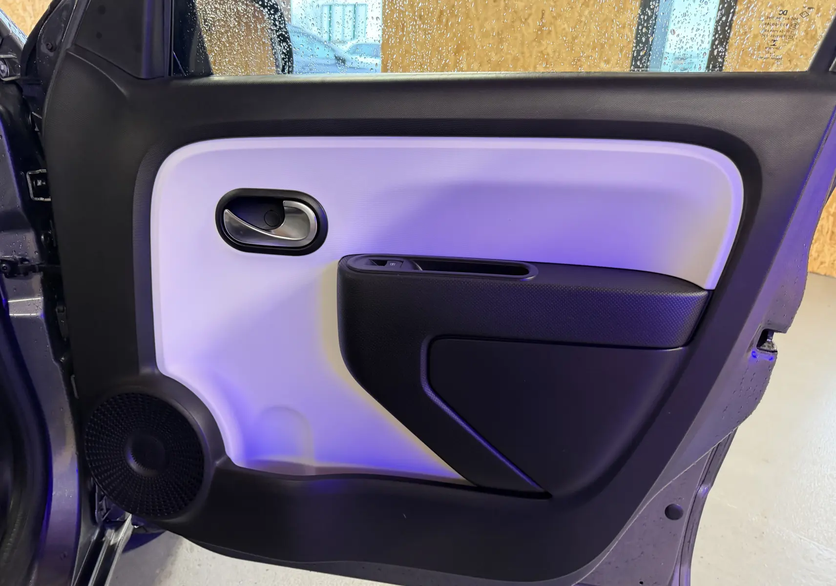 Vue intérieure de la porte arrière gauche gris clair et noir de la Renault Twingo III 2018 avec haut-parleur intégré.