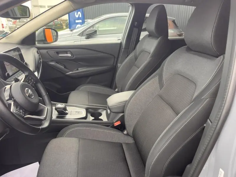 Vue intérieure côté conducteur du Nissan Qashqai 1.3 Mild Hybrid 2022 avec sièges tissu noir et gris et volant cuir multifonction.