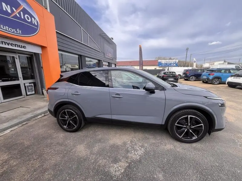 Vue de profil côté gauche du Nissan Qashqai 1.3 Mild Hybrid gris Argile avec toit noir, jantes alliage noires.