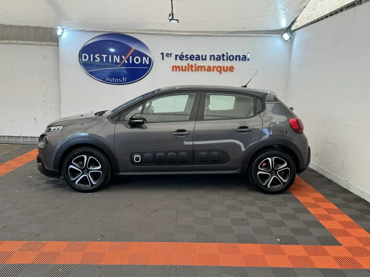 Profil côté gauche d'une Citroën C3 gris foncé 2020 avec protections latérales noires et jantes stylisées.