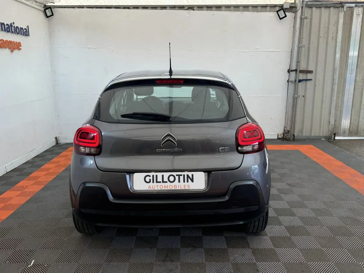 Vue arrière d'une Citroën C3 gris foncé 2020 avec feux LED et logo centré sur un sol à damier noir et orange.
