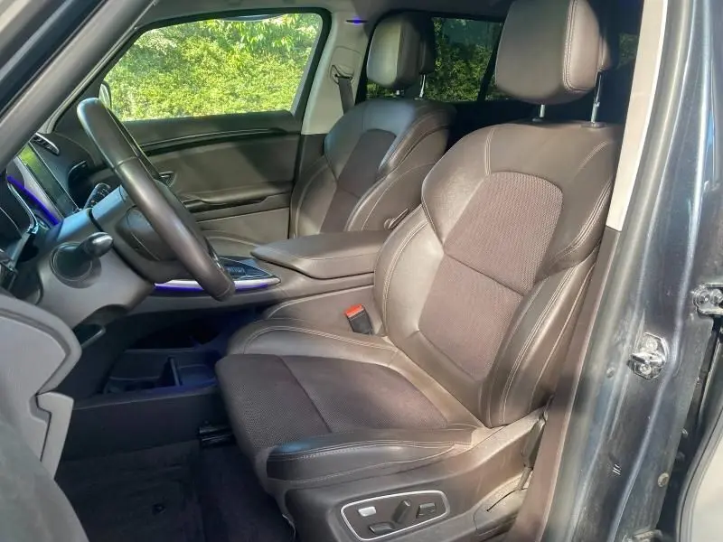 Vue intérieure côté conducteur du Renault Espace V gris 2018, sièges cuir noirs avec réglages électriques et volant multifonction.