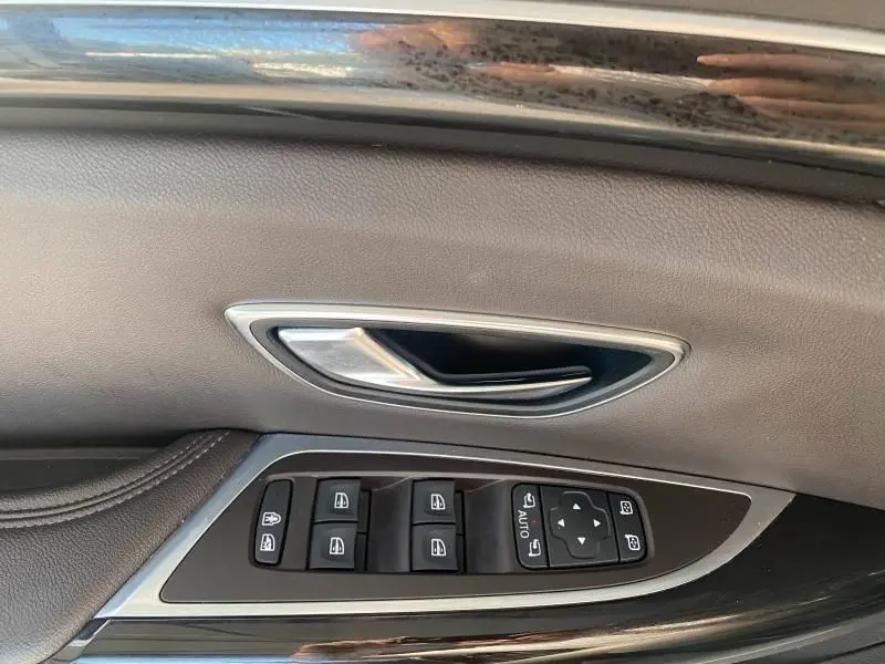 Poignée de porte intérieure côté gauche en cuir gris avec commandes électriques des vitres sur Renault Espace V gris.