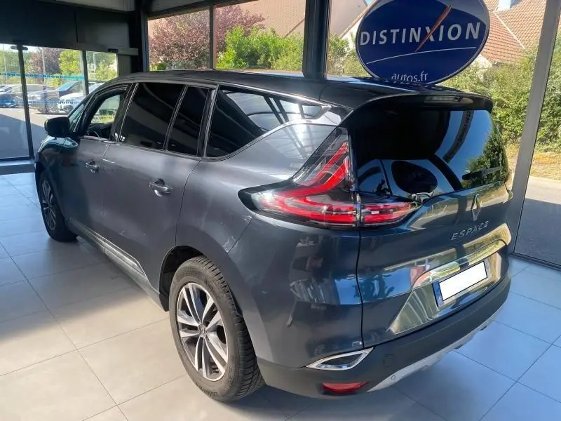 Vue 3/4 arrière droite d'un Renault Espace V gris métallisé avec vitres surteintées et feux LED distinctifs.