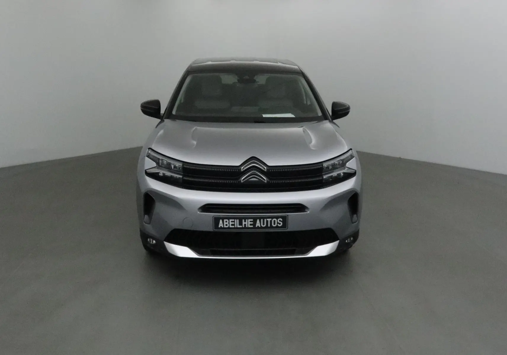 Vue frontale d'un Citroën C5 Aircross 2024 gris Artense avec calandre noire et plaque Abeilhe Autos.