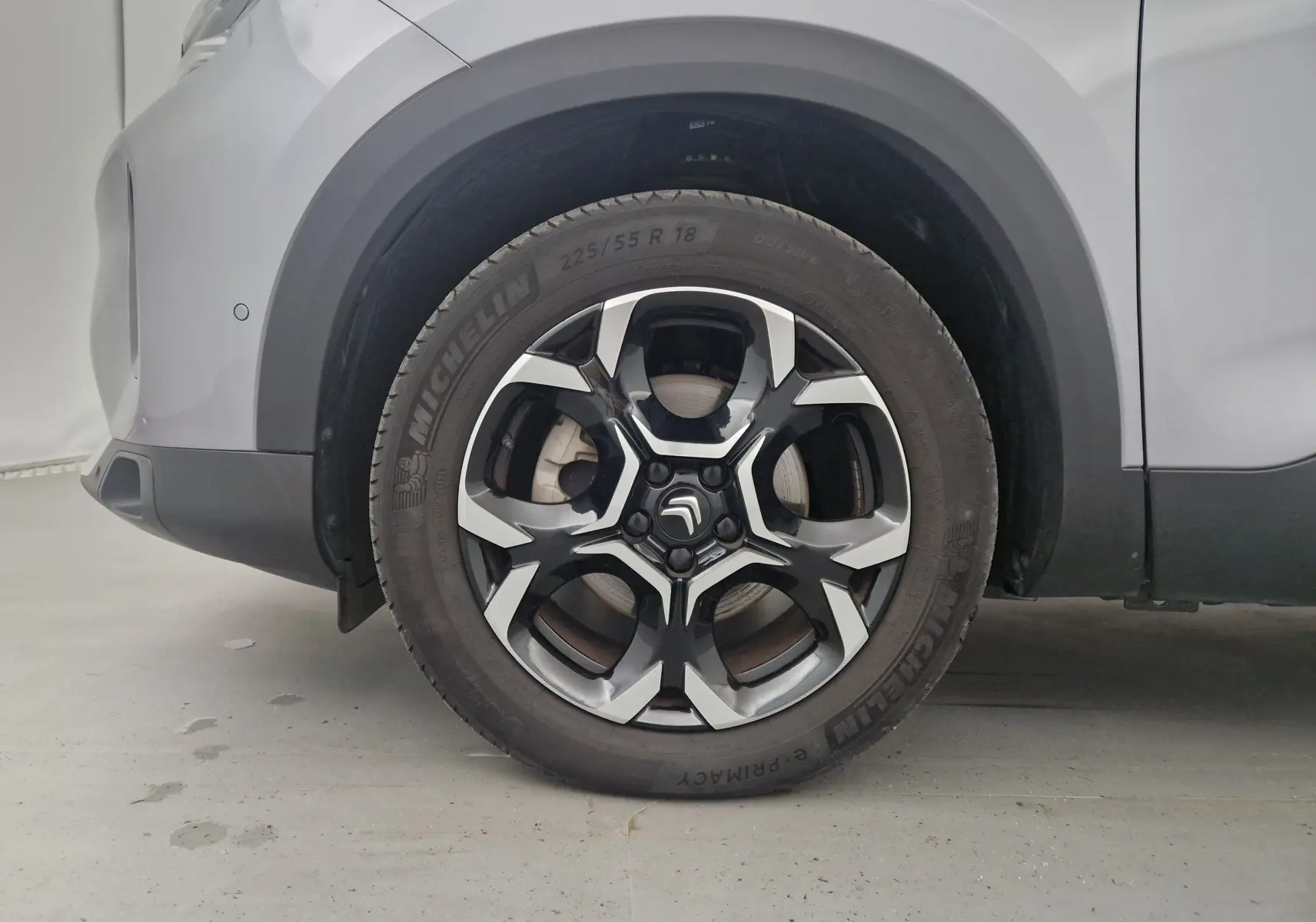 Gros plan sur la roue avant gauche du Citroën C5 Aircross 2024 gris Artense avec jante alliage noire et argentée.