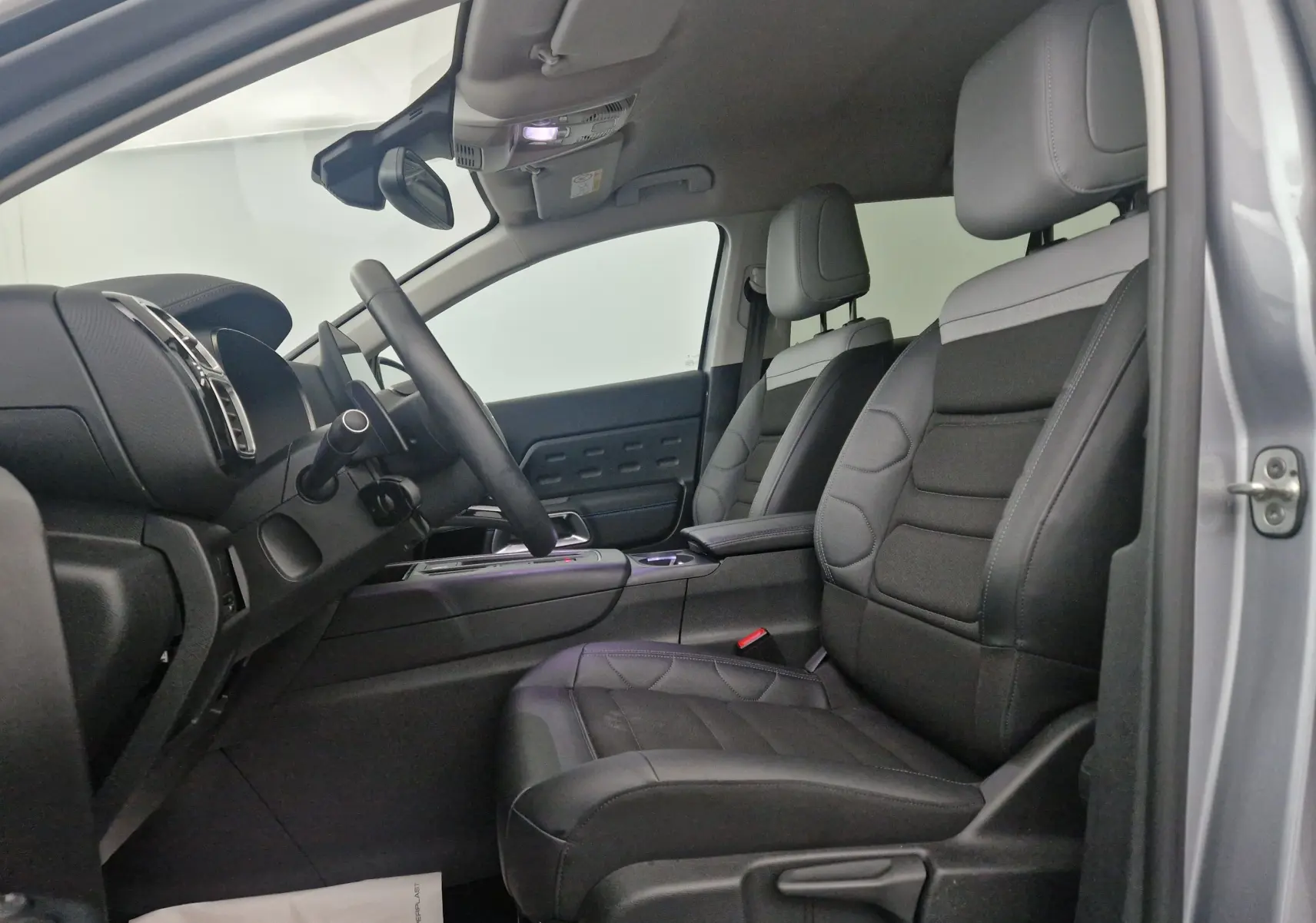 Intérieur côté conducteur du Citroën C5 Aircross 2024 gris Artense, sièges cuir noir et tableau de bord moderne.