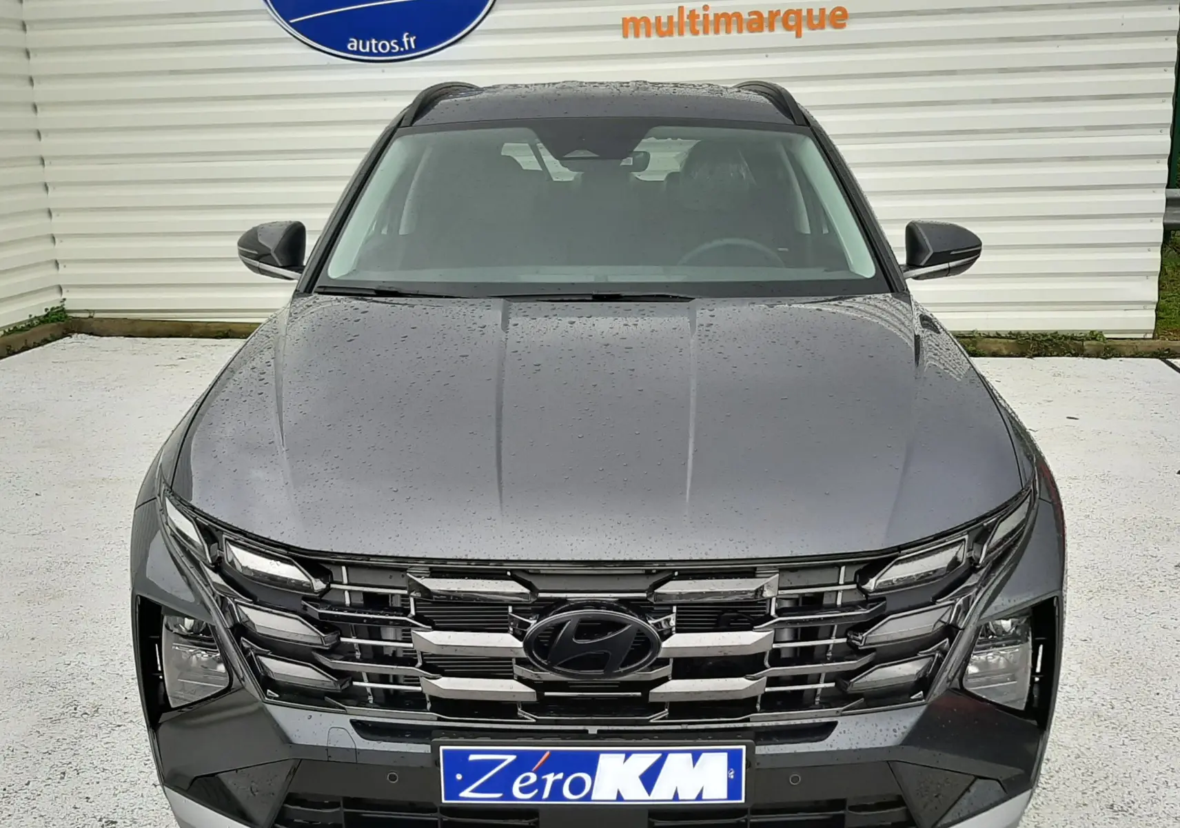 Vue de face du Hyundai Tucson 2025 gris Ecotronic, mettant en valeur sa calandre chromée et ses phares LED distinctifs.