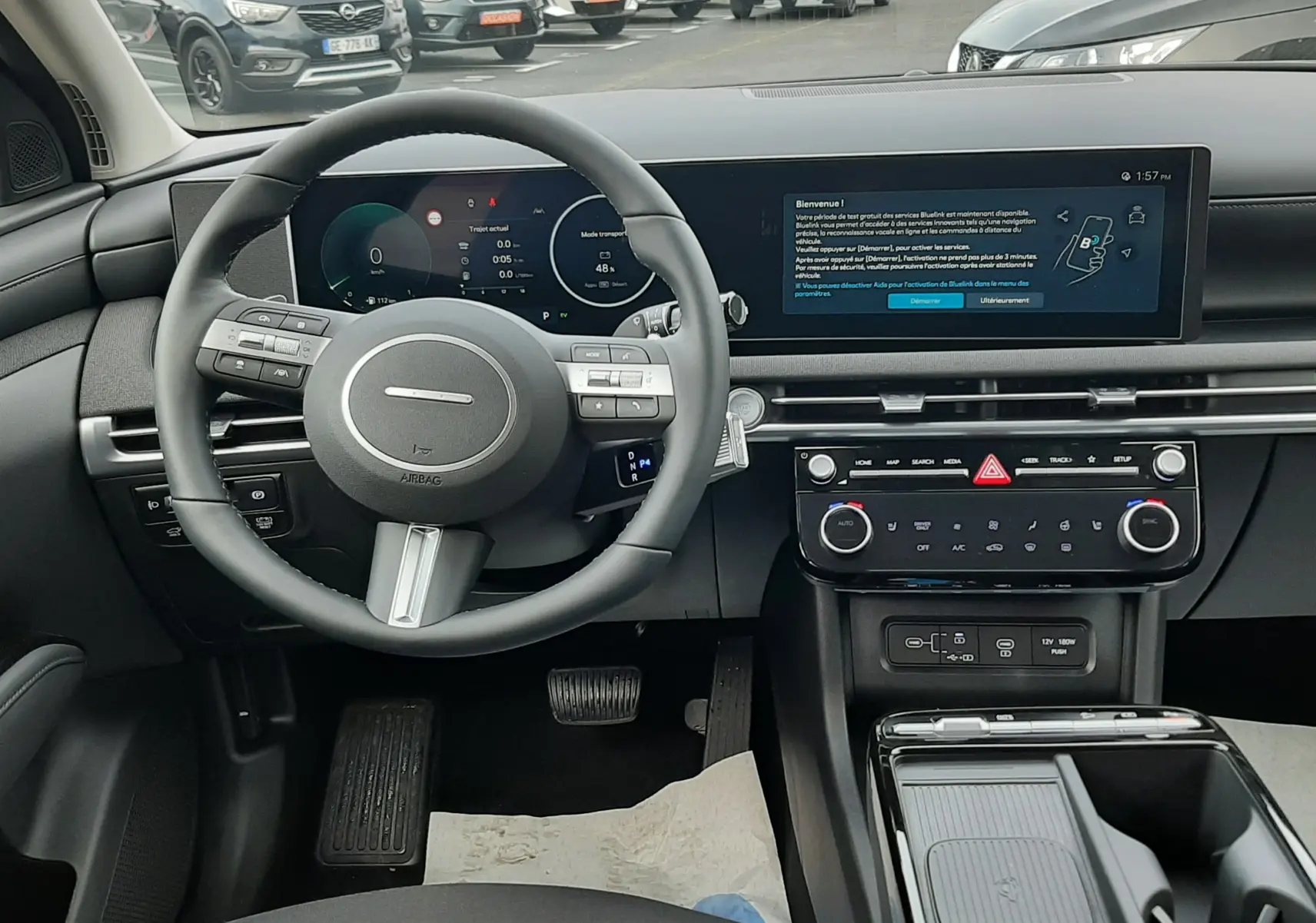 Vue intérieure du tableau de bord du Hyundai Tucson 2025 en Ecotronic Grey, avec écran digital large et volant multifonction noir.