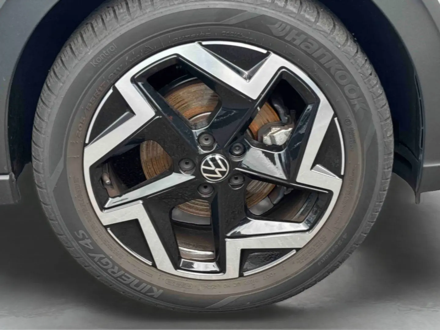 Gros plan sur la jante alliage noir et argentée de Volkswagen Taigo avec logo VW au centre et pneu Hankook.