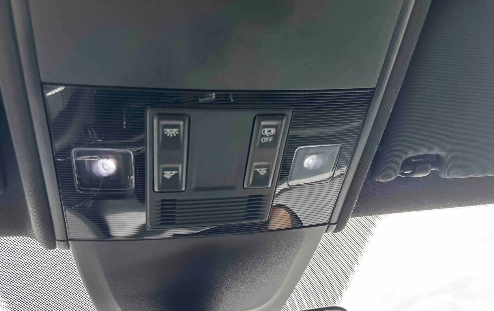 Vue en contre-plongée du plafonnier noir du Volkswagen Taigo 2025 avec commandes d’éclairage intégrées.