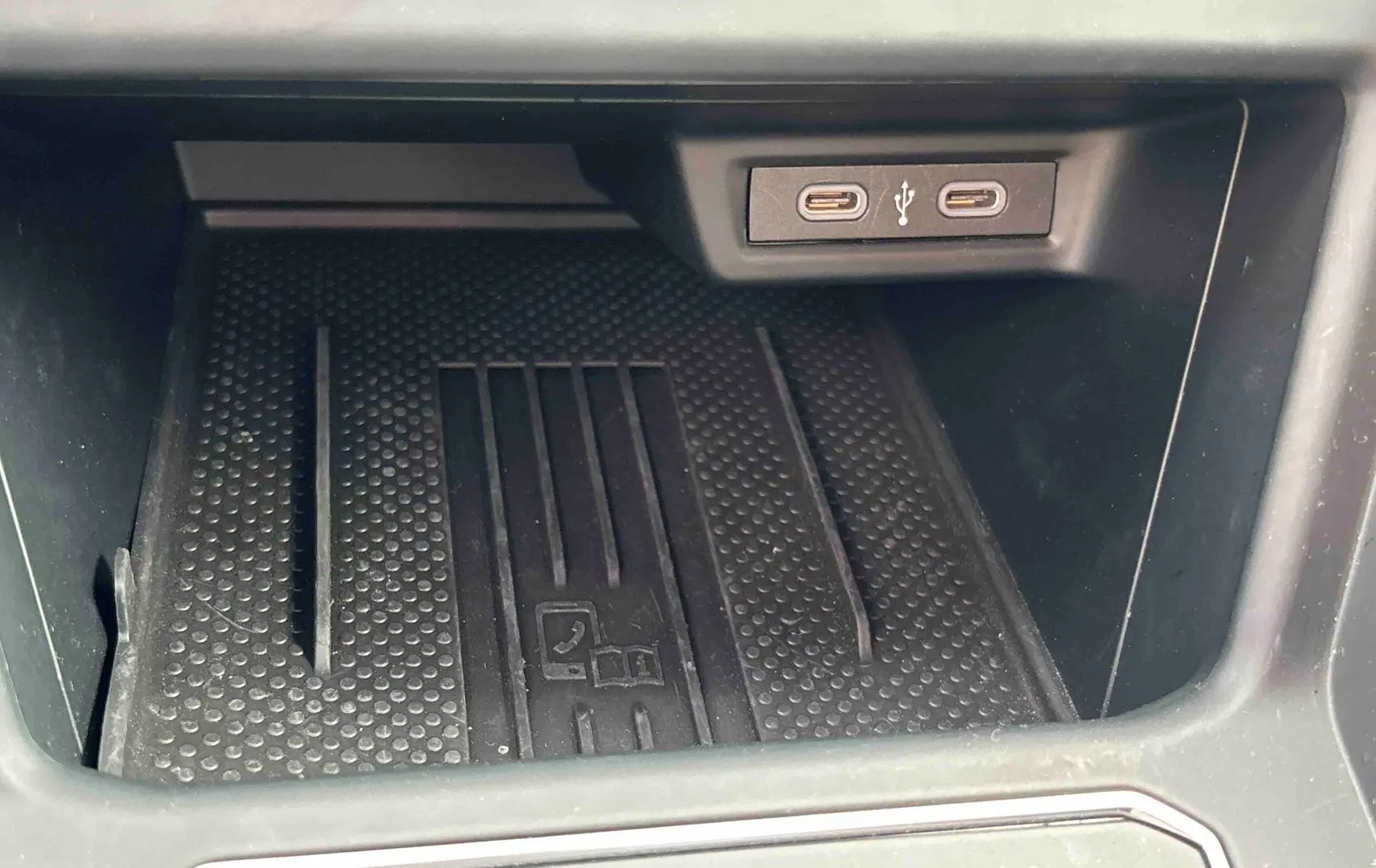 Gros plan sur la zone de chargement avec deux ports USB-C dans l’habitacle du Volkswagen Taigo blanc.