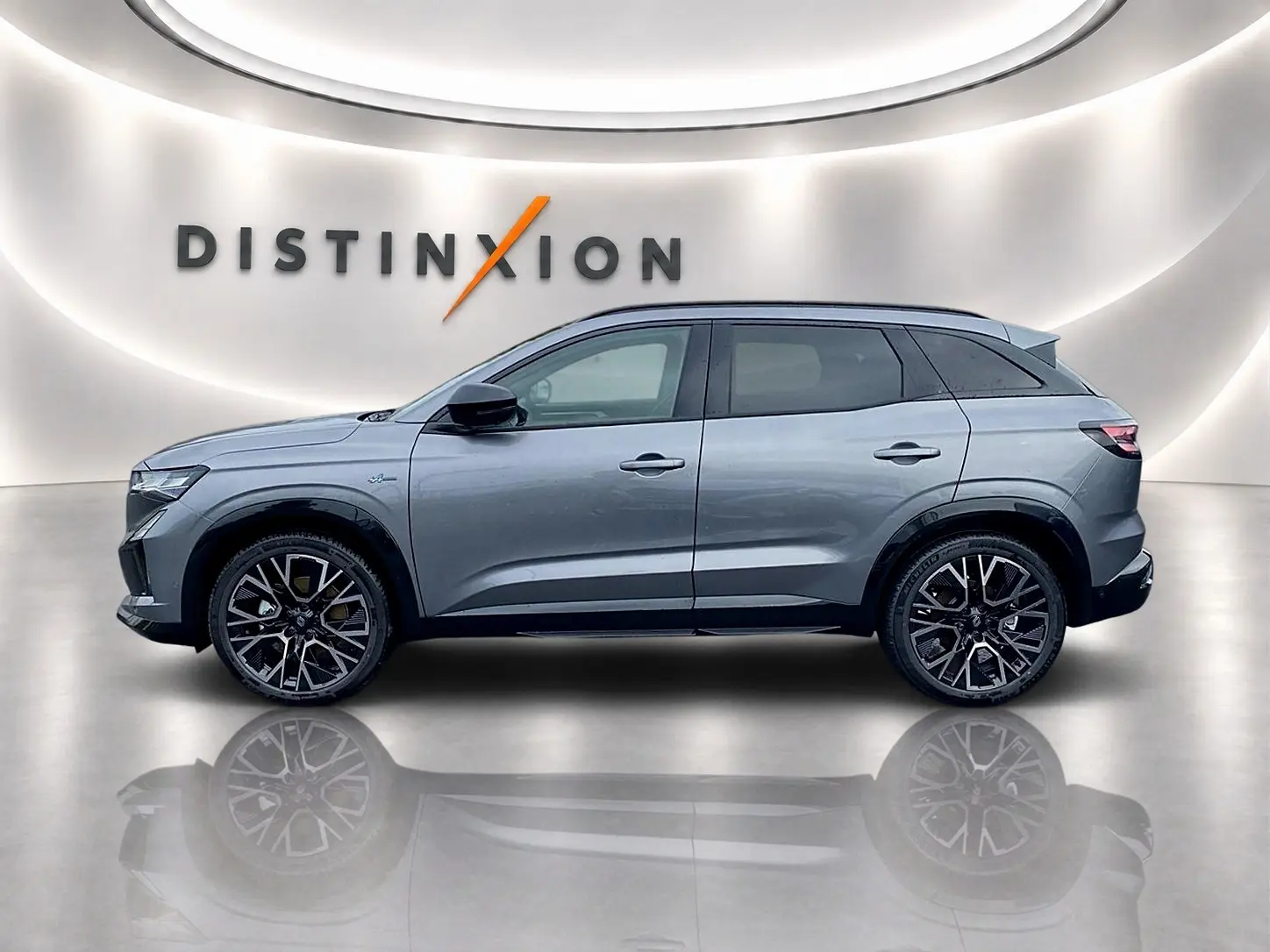 Profil droit du Renault Austral gris schiste 2026 avec jantes alu noires et toit noir dans un showroom lumineux.