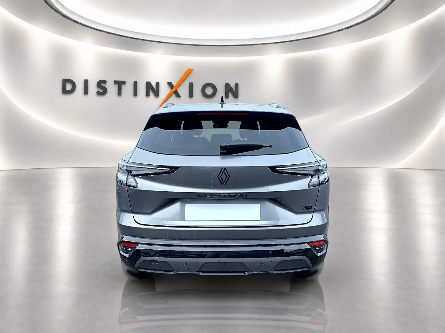 Vue arrière du Renault Austral gris schiste avec feux LED et logo distinctif sur fond lumineux "Distinxion".