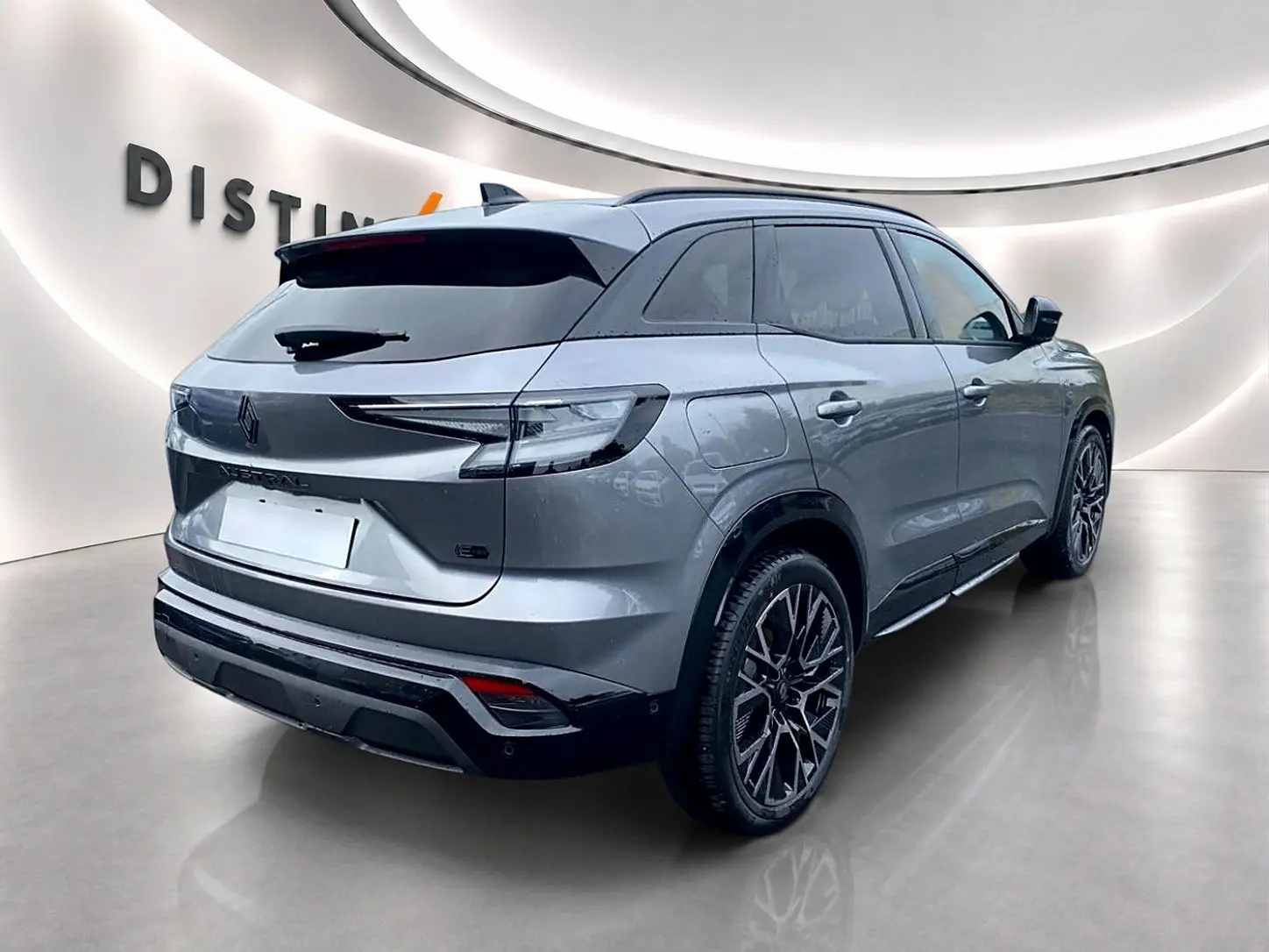 Vue 3/4 arrière droite du Renault Austral gris schiste avec jantes alu et becquet arrière visible en showroom.